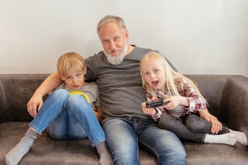 Elderly Man Sitting on Sofa with Kids