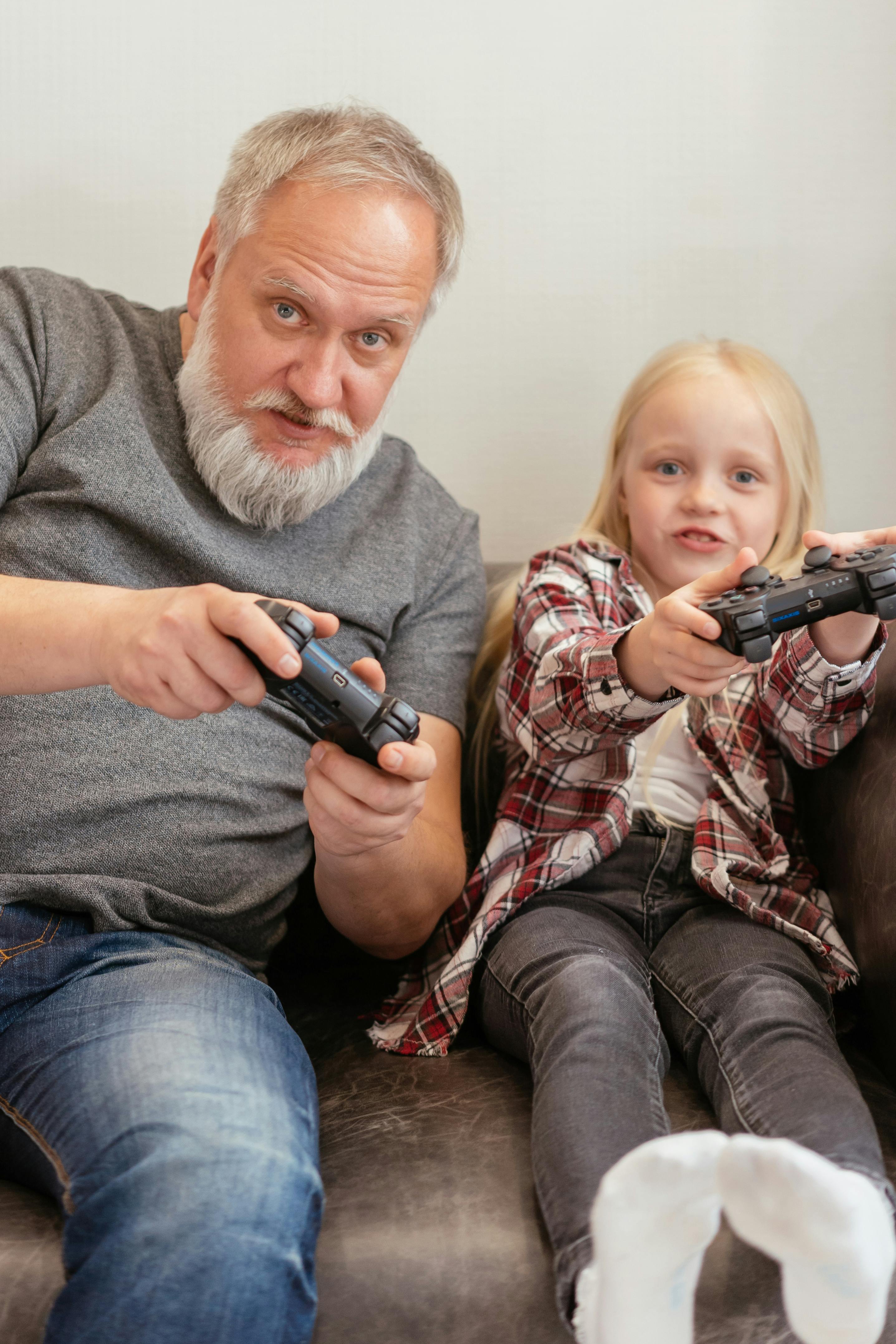 a man and girl playing game using joysticks