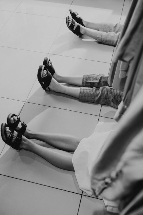 Grayscale Photo of People Wearing Sandals