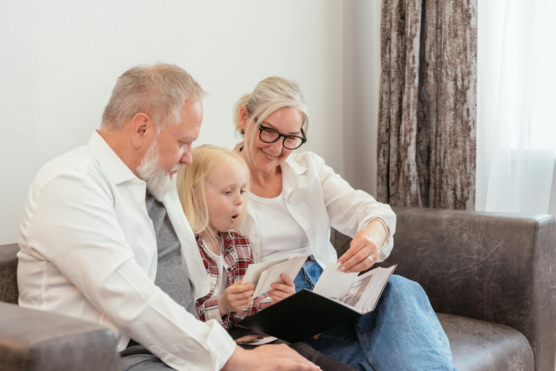 A Little Girl and her Grandparents Looking at Photos