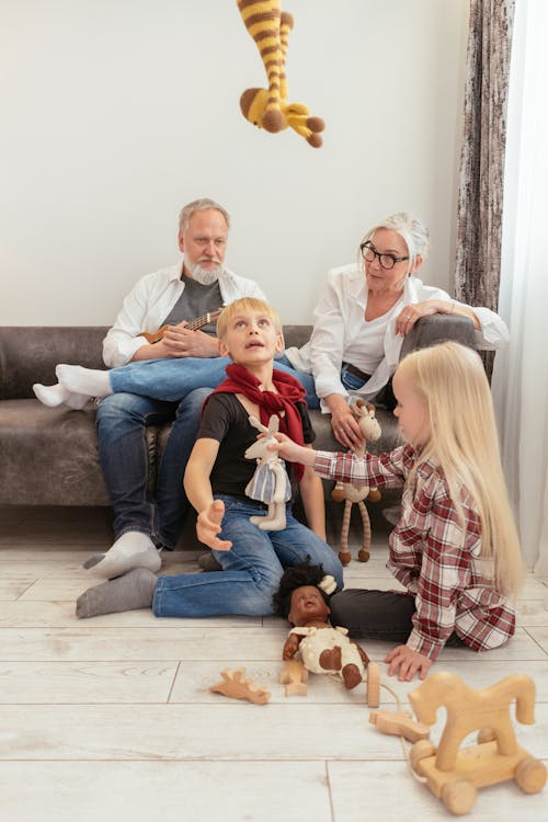 Free Children Playing in a Living Room with their Grandparents Stock Photo