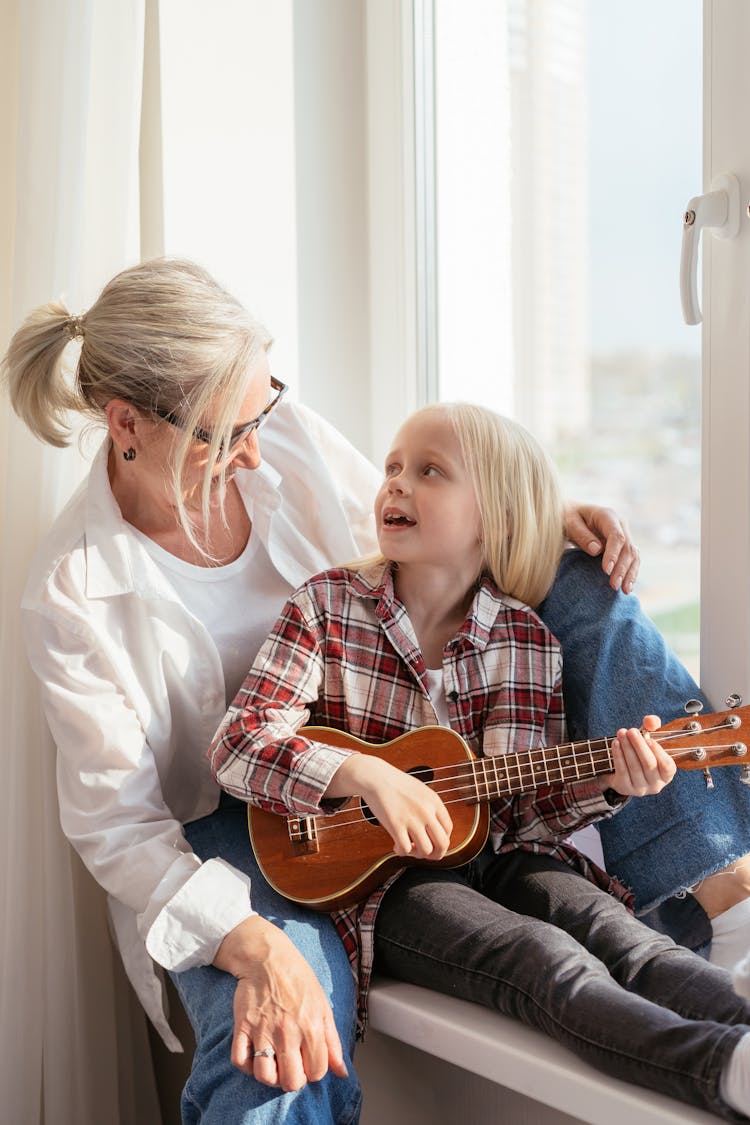 Woman And Child Sitting On The Window Sill