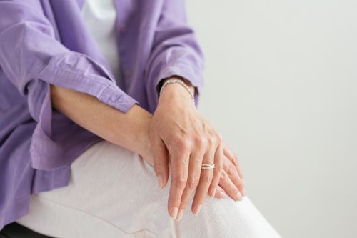 Free A close-up of a woman's hands gently resting on her lap, showcasing a sense of calm and elegance. Stock Photo