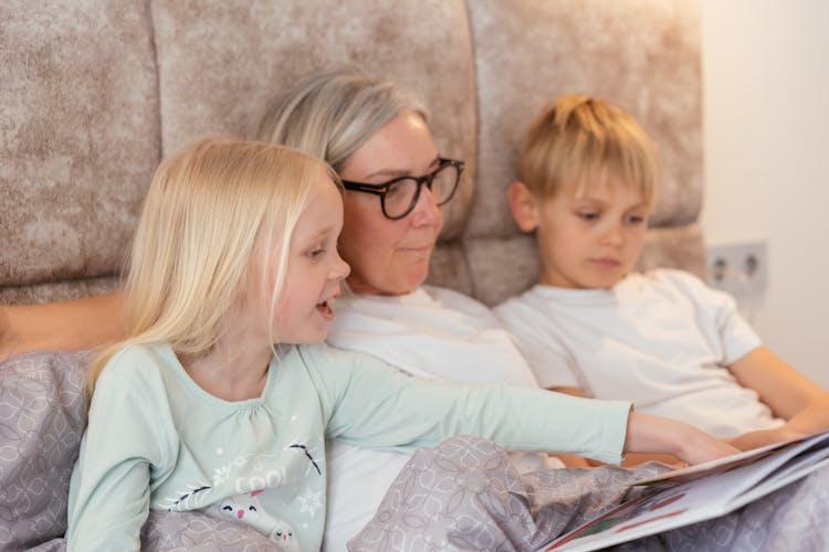 Woman Reading Story Book With Children  