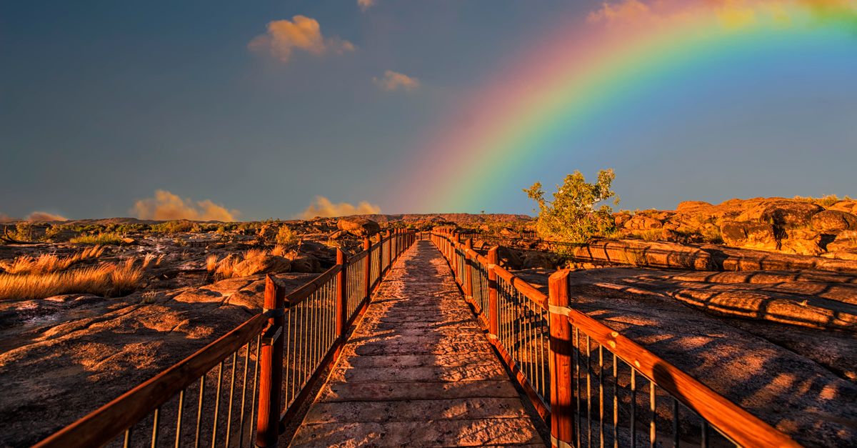 Rüyada Gökkuşağı Görmek - Rüya Tabiri ve Anlamı - A scenic walkway with a rainbow arching across a vivid sky, perfect for outdoor photography.