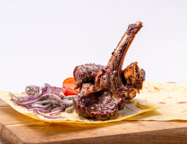 Grilled Lamb Chop With Sliced Onions On A Pita