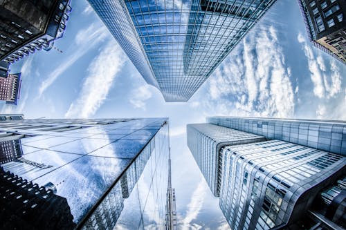 Kostenlos Flachwinkelfoto Von Vier Hochhausfassaden Unter Weißen Wolken Und Blauem Himmel Stock-Foto