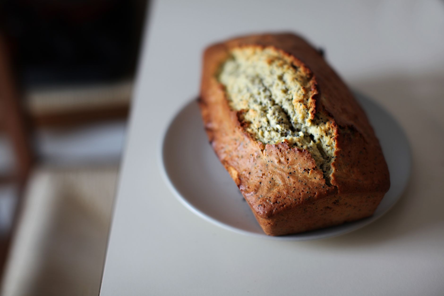 Slice of lemon yogurt pound cake on a plate with fresh lemon wedges