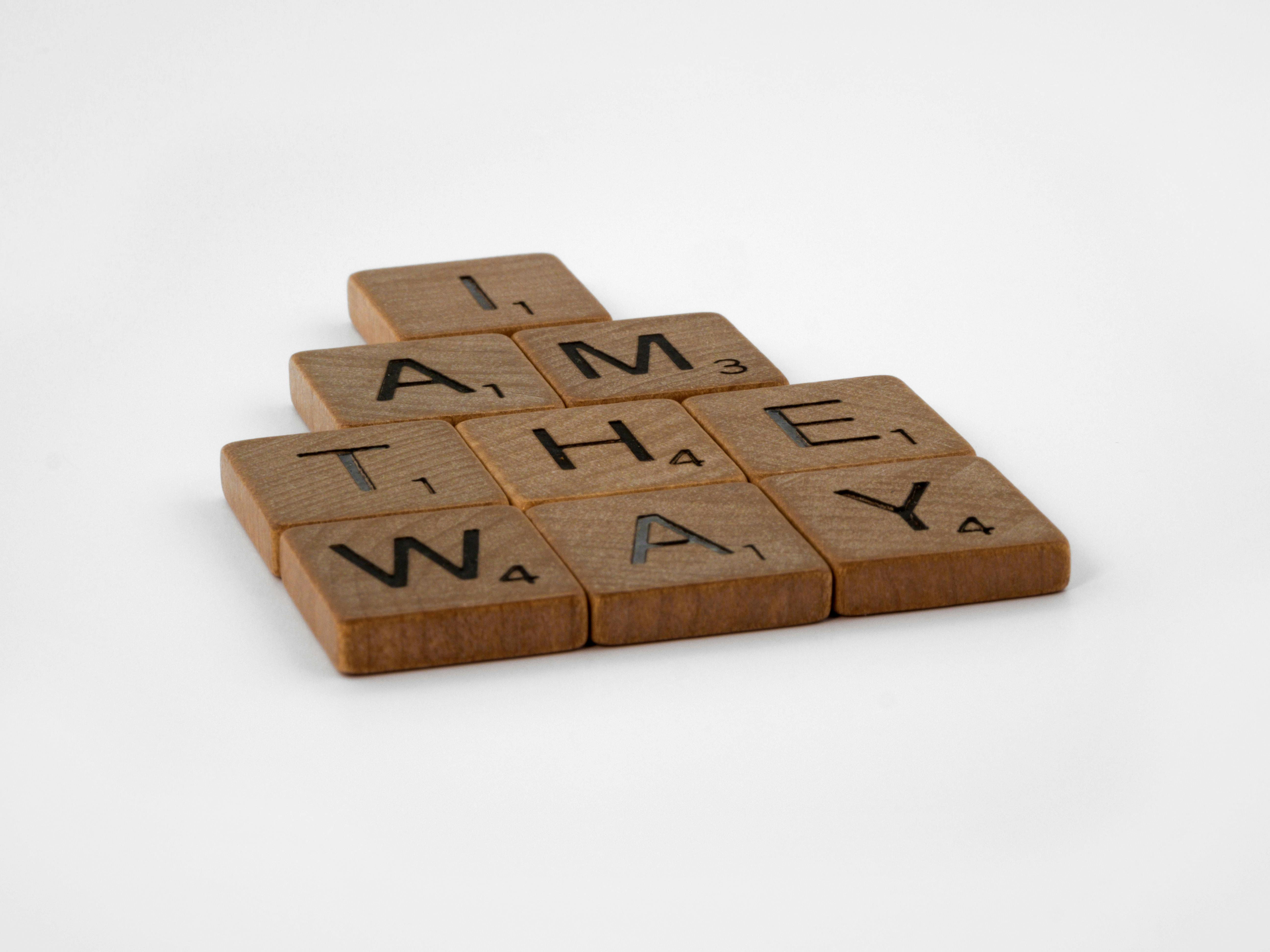 brown wooden scrabble pieces on white surface