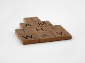 Brown Wooden Scrabble Pieces on White Surface