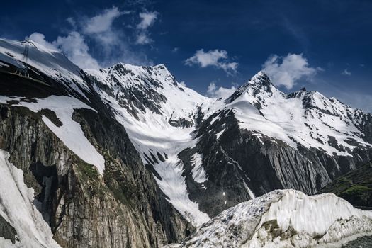 Stunning view of snow-covered peaks against a bright blue sky, showcasing the beauty of winter.