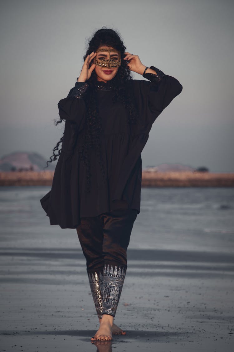 Woman With A Mask Walking On The Beach