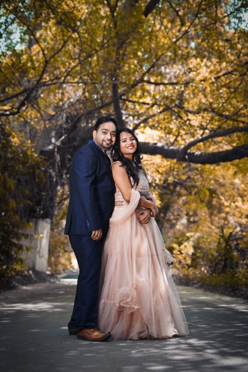 Free A joyful couple embracing under autumn leaves, exuding happiness. Stock Photo