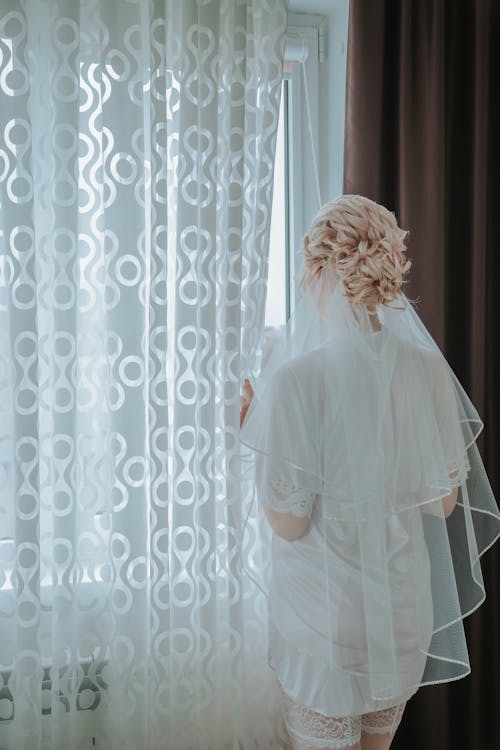 Woman in White Veil Standing Near Window