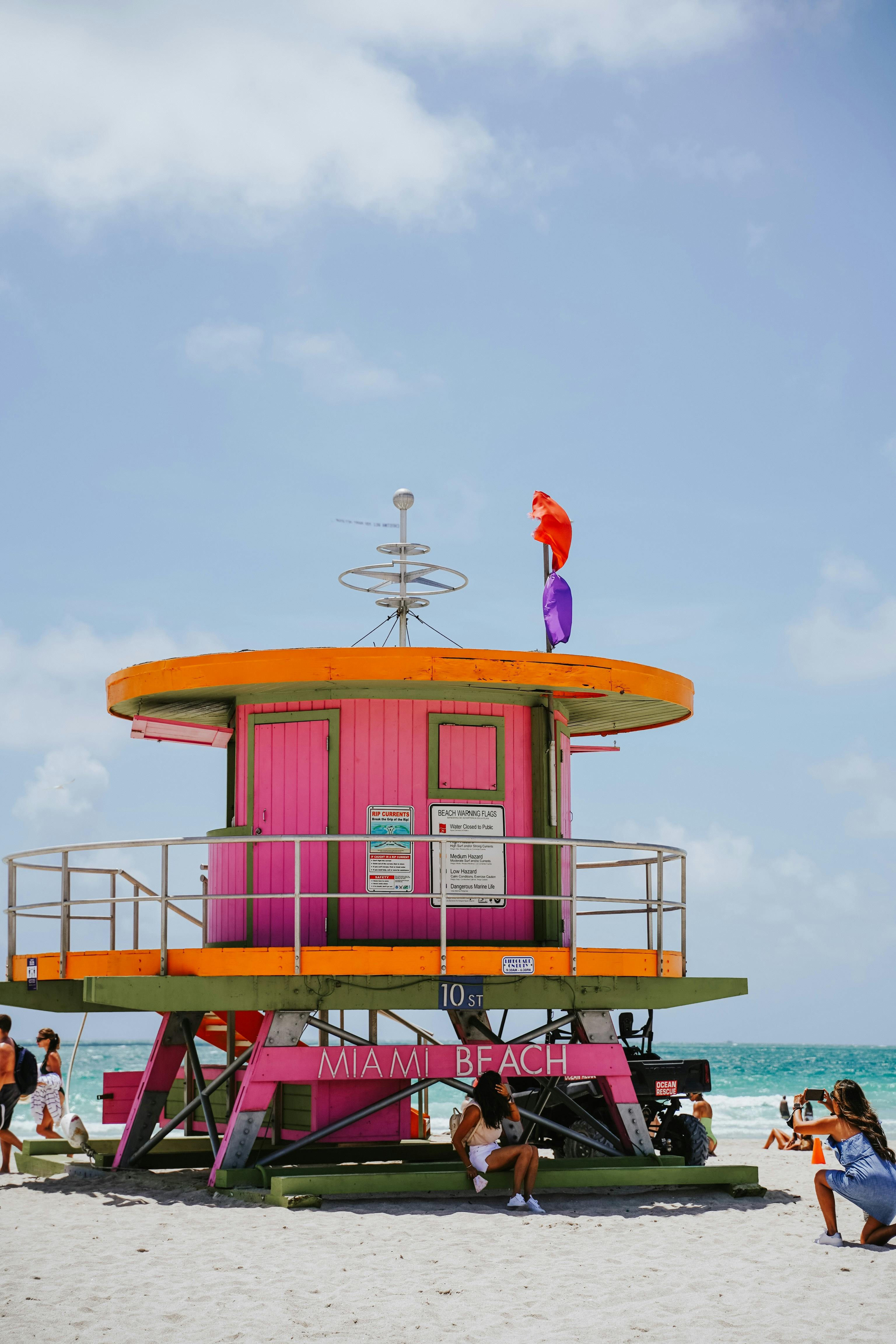 Colorful lifeguard tower on Miami Beach with people enjoying the sunny day. Ideal for travel and lifestyle themes.