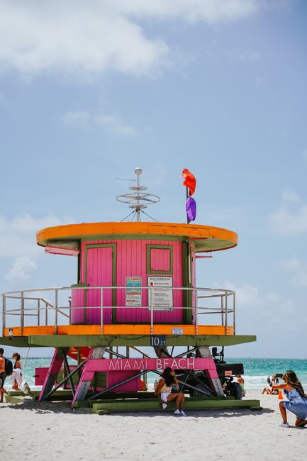 Colorful lifeguard tower on Miami Beach with people enjoying the sunny day. Ideal for travel and lifestyle themes.