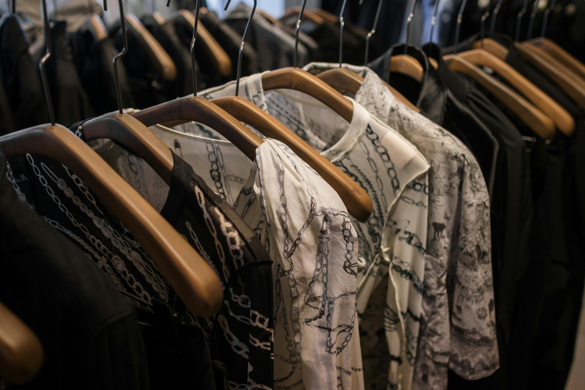 Elegant clothes on wooden hangers showcasing chic pattern designs in a boutique.