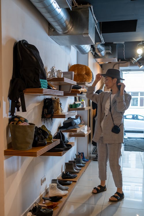 A Woman Trying on a Hat in a Fashion Boutique