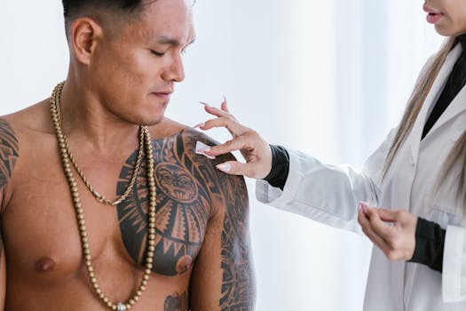 A man with tribal tattoos receives acupuncture from a practitioner in a spa setting.
