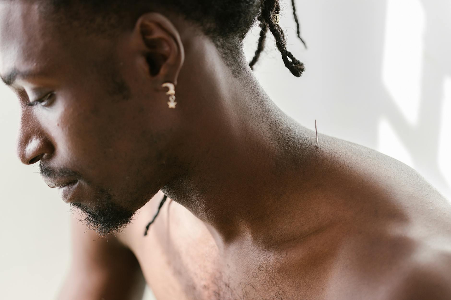 https://www.pexels.com/photo/close-up-shot-of-a-man-with-needle-on-his-shoulder-8312806/
