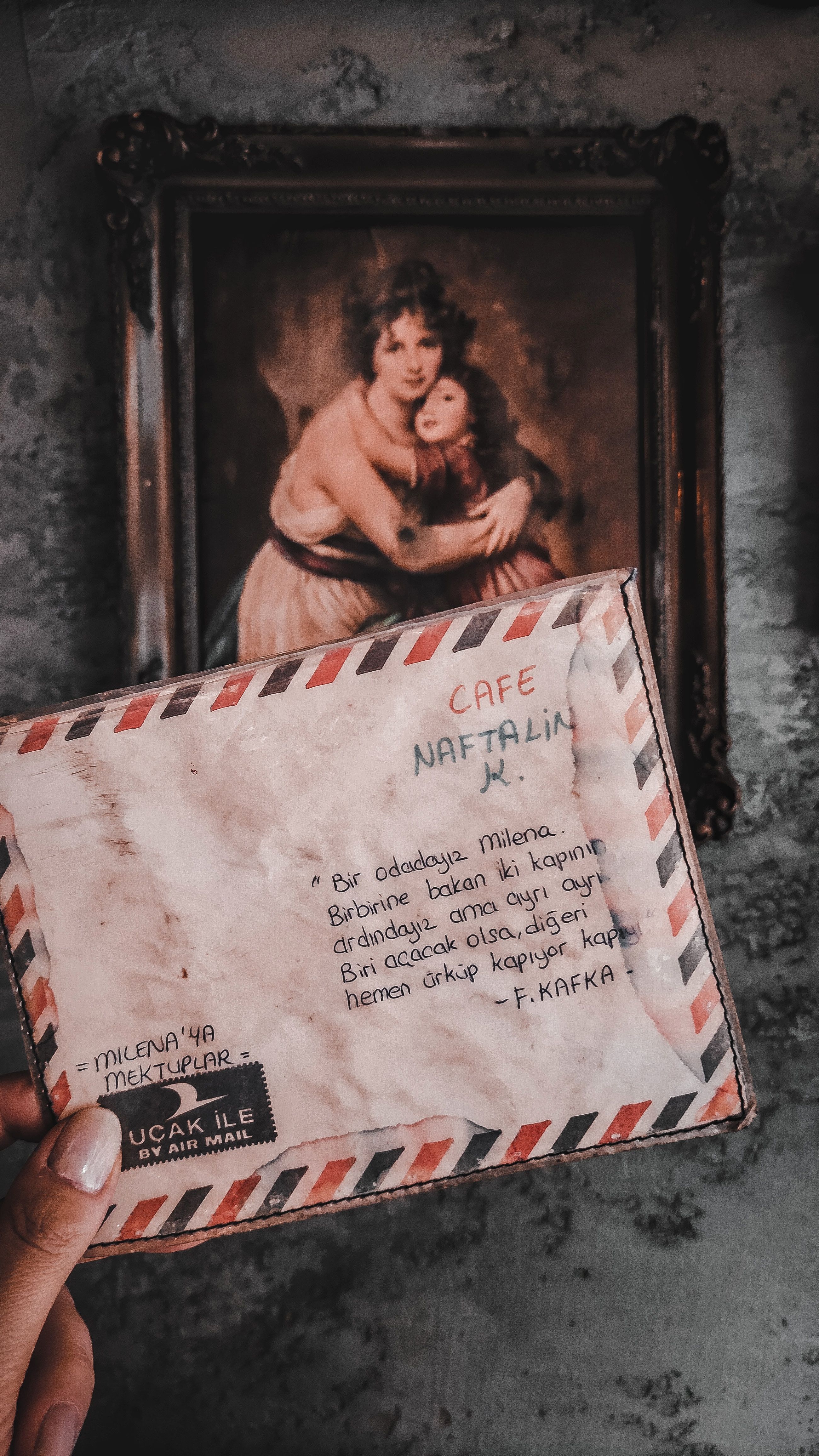 Vintage letter and framed portrait evoke a sense of nostalgia against a rustic background.