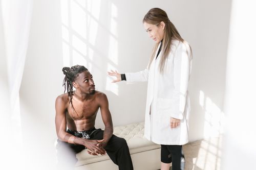 Free Doctor and patient discussing treatment options in a bright room. Stock Photo