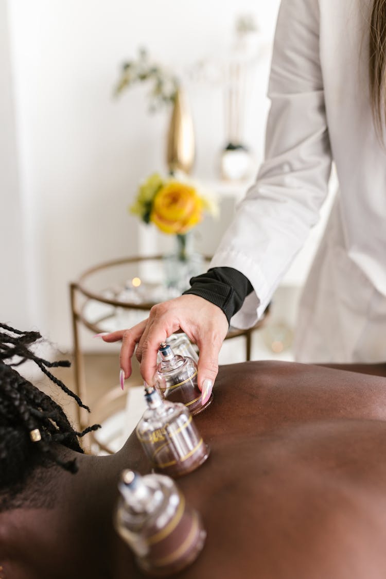 A Therapist Putting Suction On A Person's Back