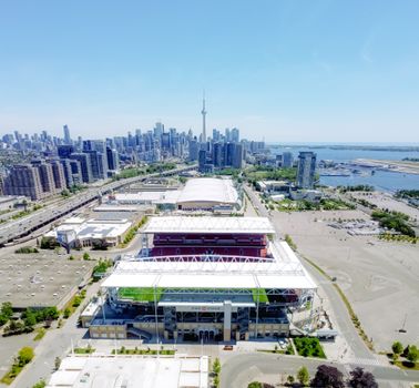 A vibrant aerial view of BMO Field with the Toronto skyline and CN Tower in the background.