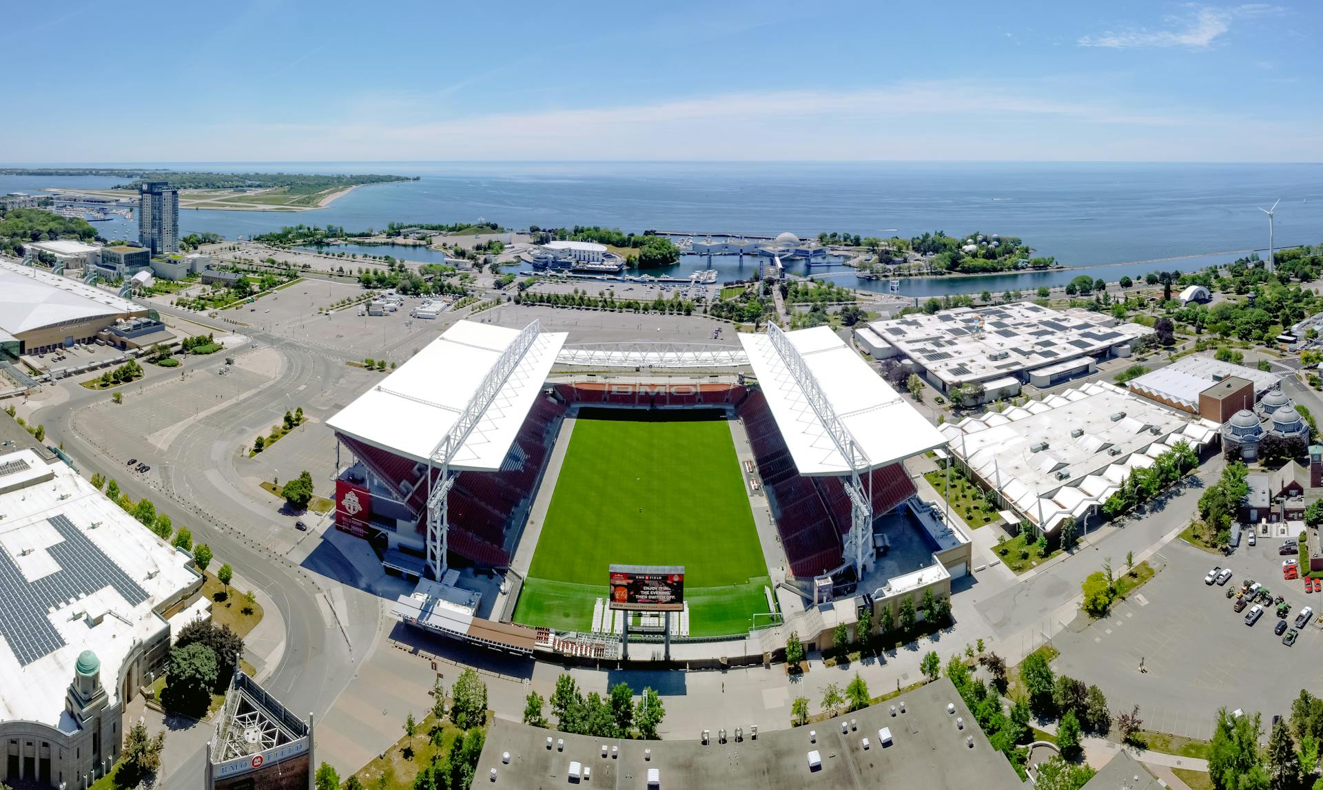 Stunning aerial view of BMO Field and Toronto's scenic waterfront on a clear summer day.