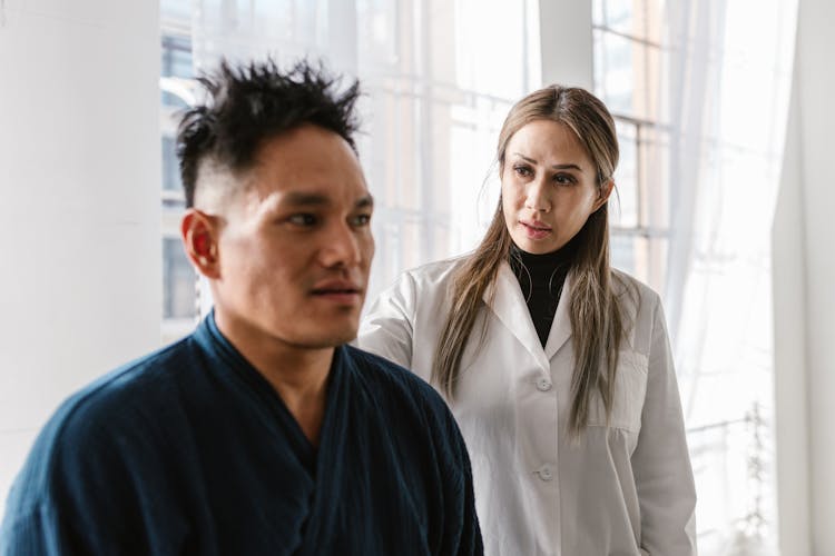 Woman In White Coat Talking To A Man In Blue Robe