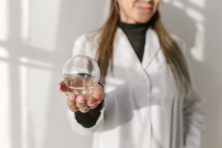 A Therapist Holding A Glass Suction