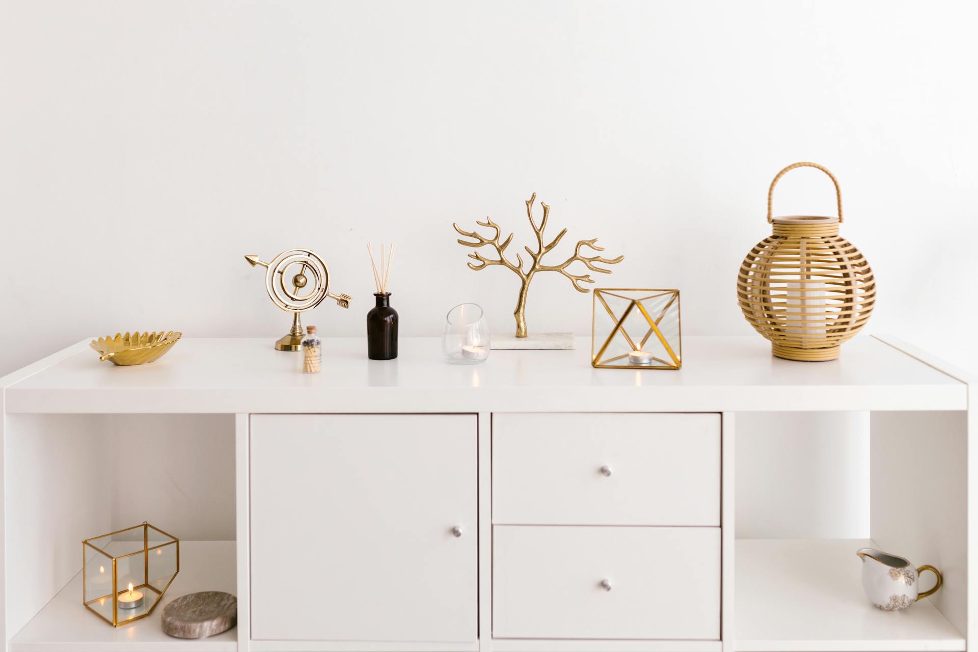 Sleek white cabinet with elegant gold decorations on a modern white background