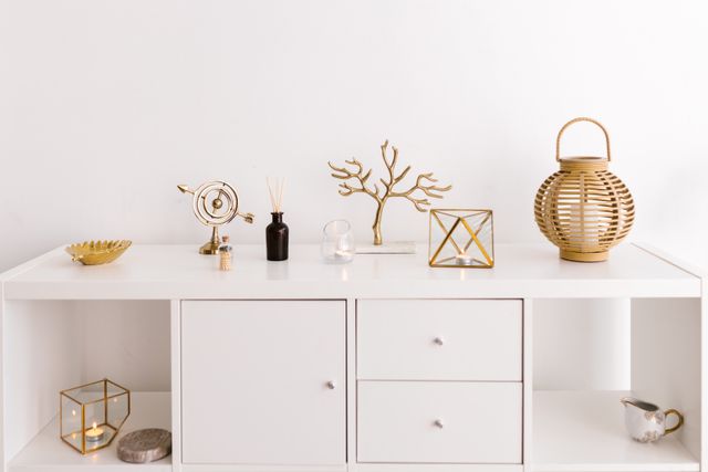Glass and brass tealight lantern on a white storage unit — RDNE Stock project on Pexels
