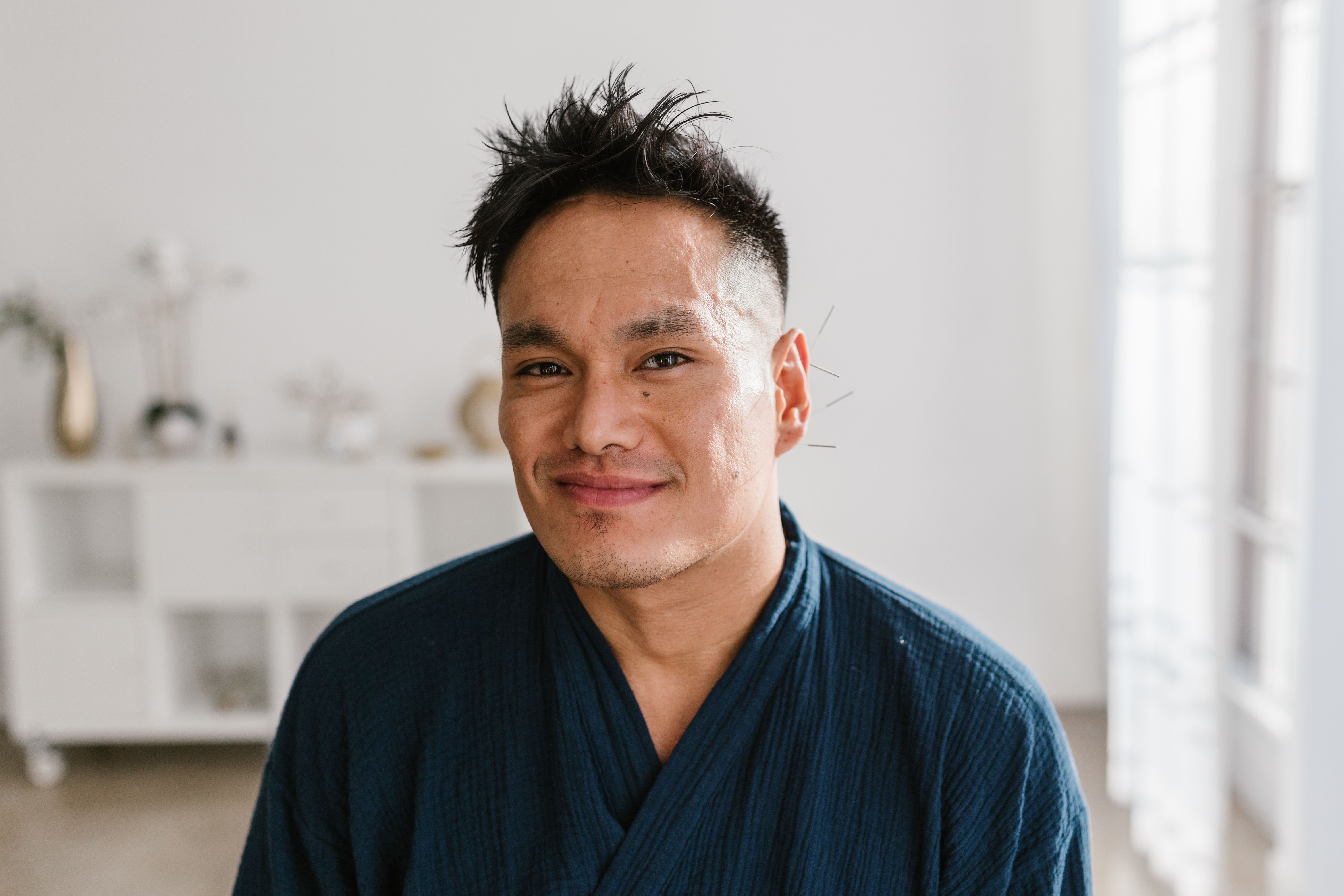 Man smiling in a wellness setting after a massage therapy appointment in Los Angeles.