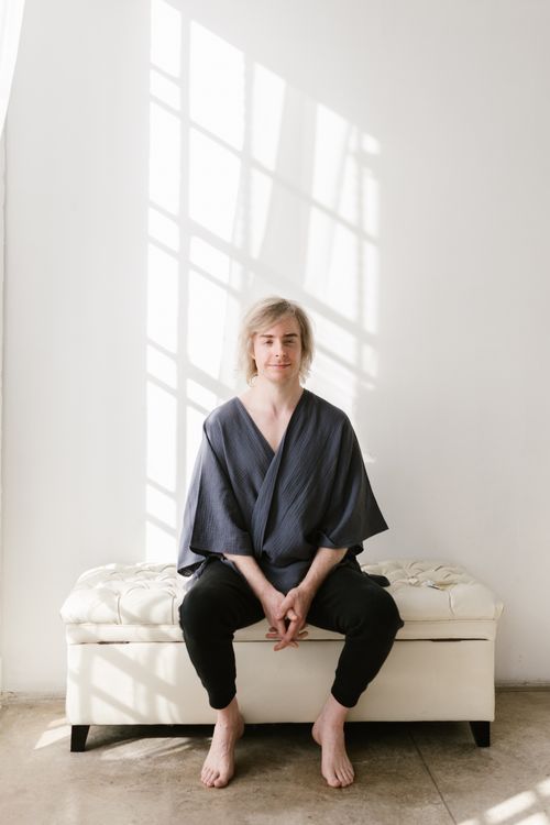 Free A caucasian man sitting casually on a couch in a sunlit room, creating a serene atmosphere. Stock Photo