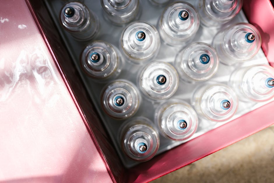 Aerial view of glass cupping therapy sets neatly arranged in a red box under sunlight.