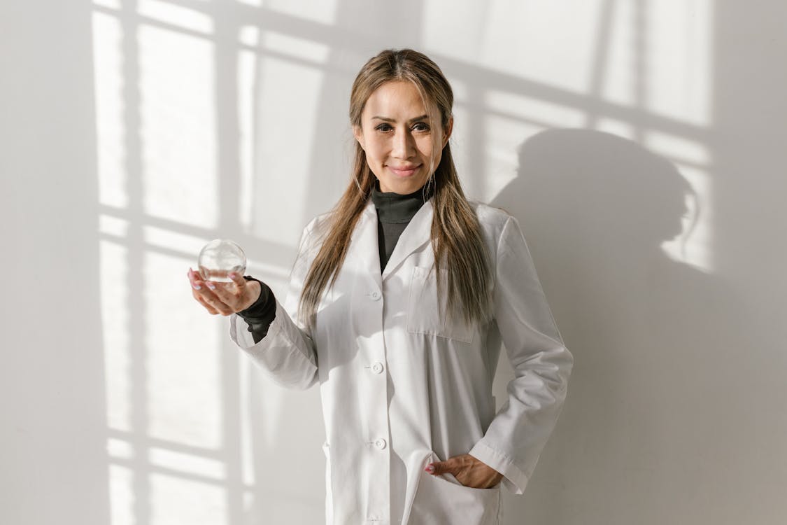 Smiling Woman in White Coat Holding a Ventosa Glass