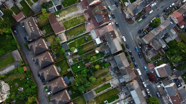 Drone view over a suburban residential area in Luton, England, showcasing houses and gardens.