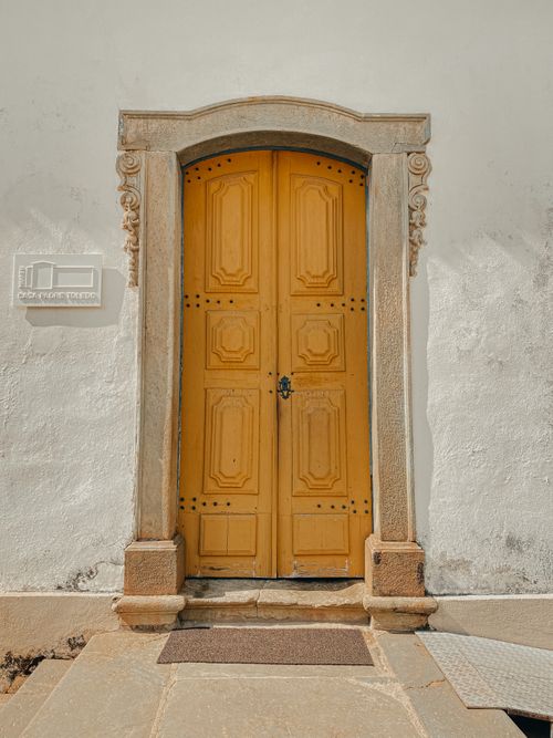 Free Elegant yellow colonial door with ornate frame in Tiradentes, Brazil. Stock Photo