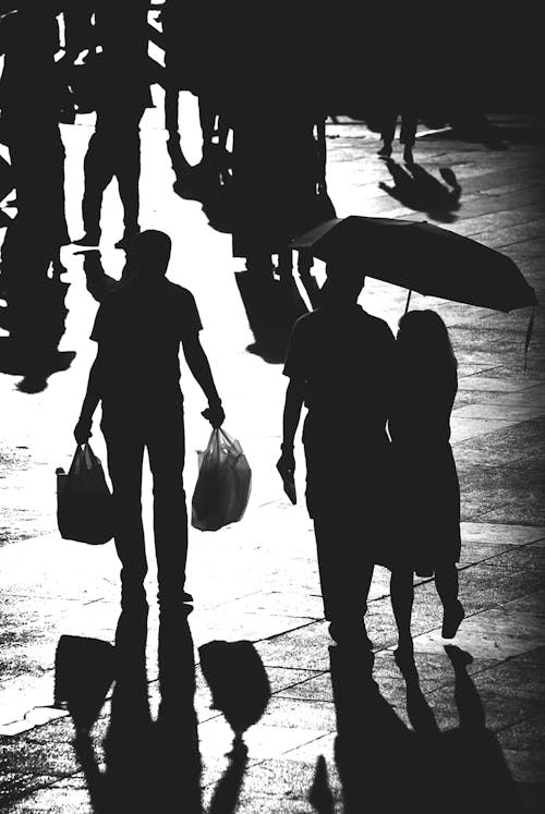 Grayscale Photo of Silhouette of People Walking on the Street