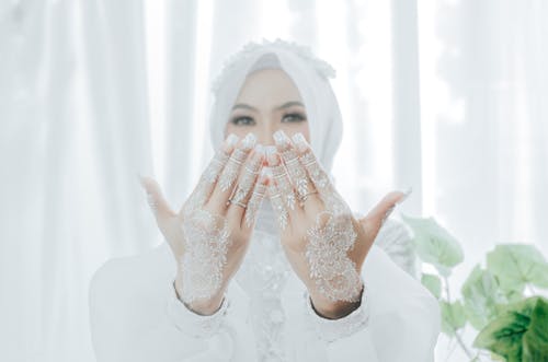 Free A Woman in White Long Sleeves with Mehndi on Her Hands Stock Photo