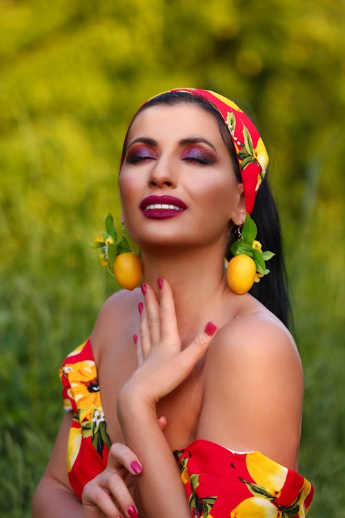 A Woman in Red Off Shoulder Top Smiling with Her Hand on Her Neck