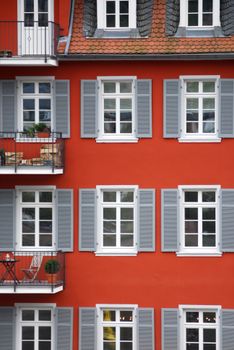 Charming red building with gray shutters and balconies in Heidelberg, Germany.
