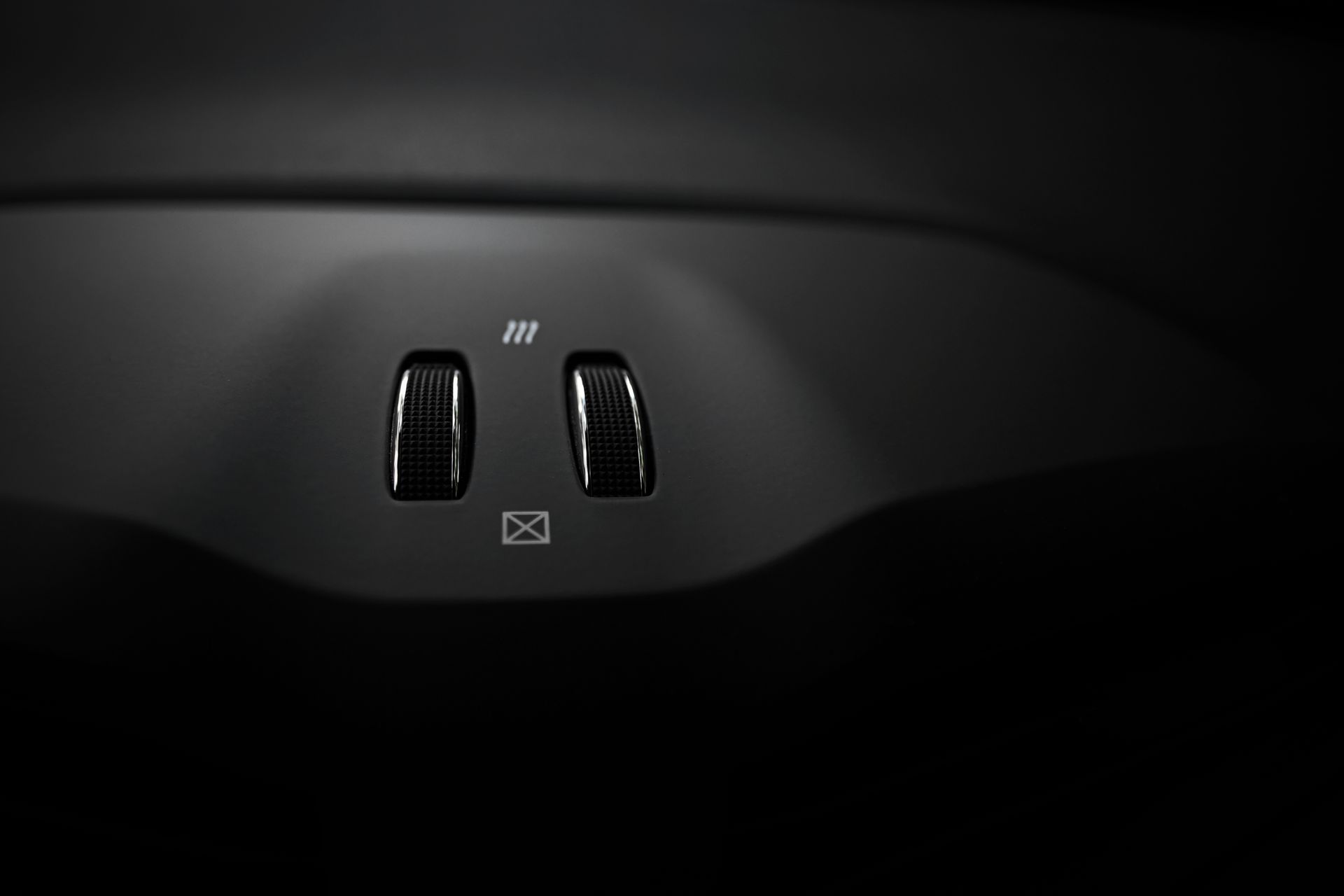 Close-up view of luxury car interior switches with sleek design.