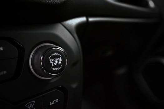 Detailed close-up of a modern car dashboard button in low light.