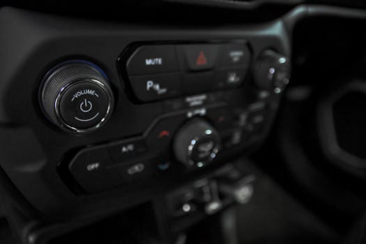 Detailed view of car dashboard featuring volume, AC, and power controls in a luxury vehicle.