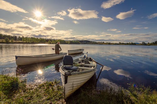 Рыбак на белой деревянной лодке