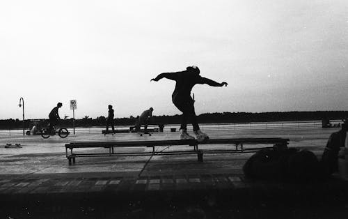 Black and White Photo of Skaters in a Skate Park