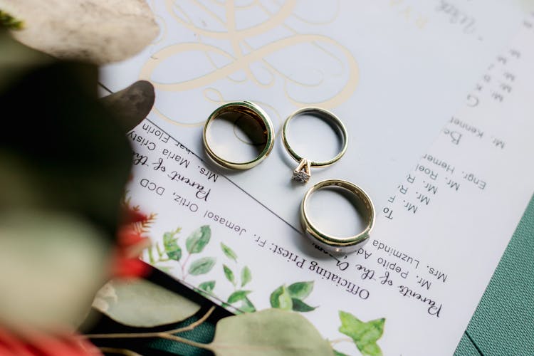 Wedding Rings Placed On Papers On Table