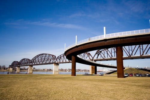 Free Low Angle Photography of Brown and Gray Bridge Under Blue Calm Sky Stock Photo
